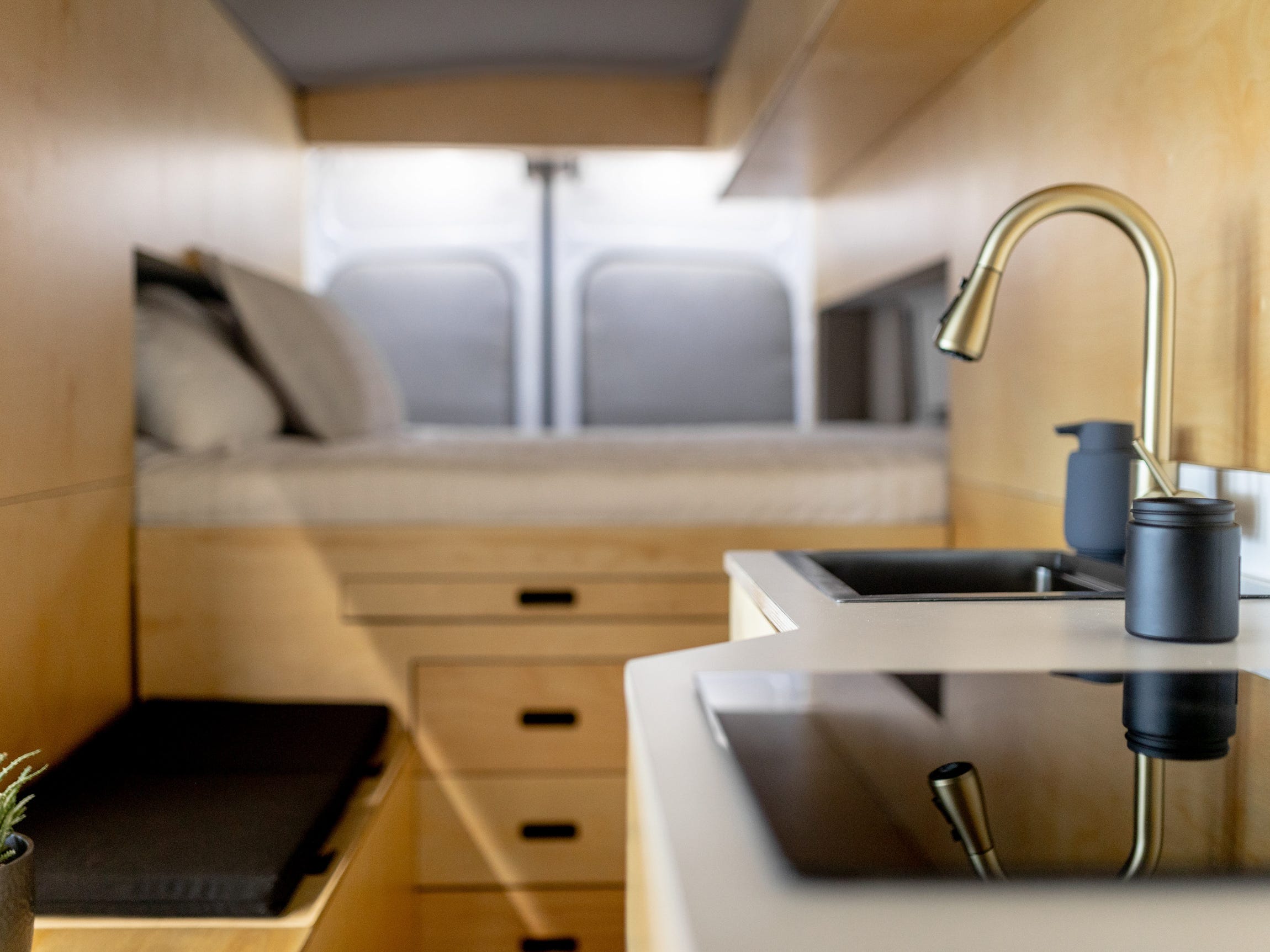 Inside Grounded's camper van with a bed, sink